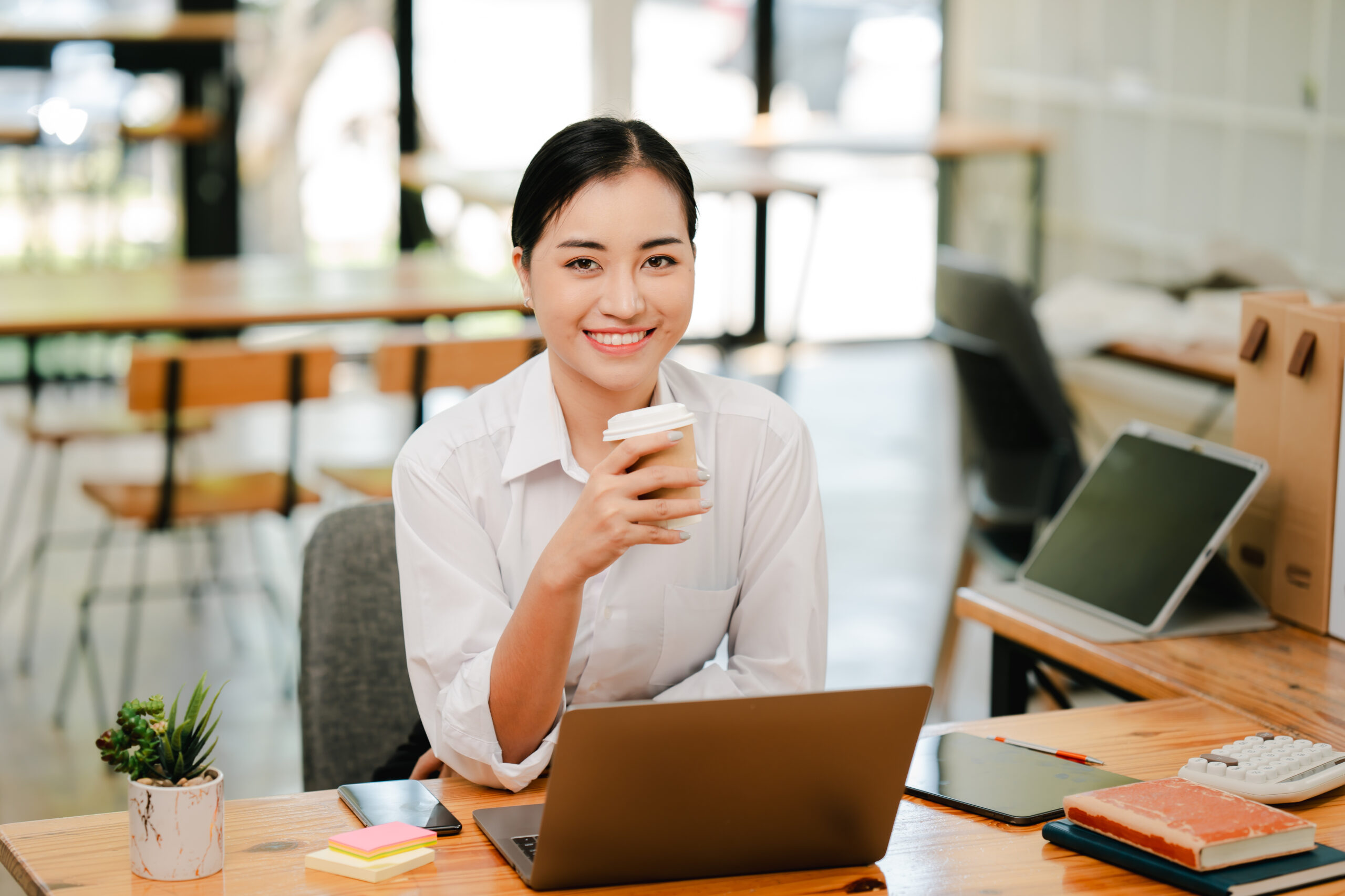 Asian female student studying online and taking notes. Female accountant doing annual financial and tax reports